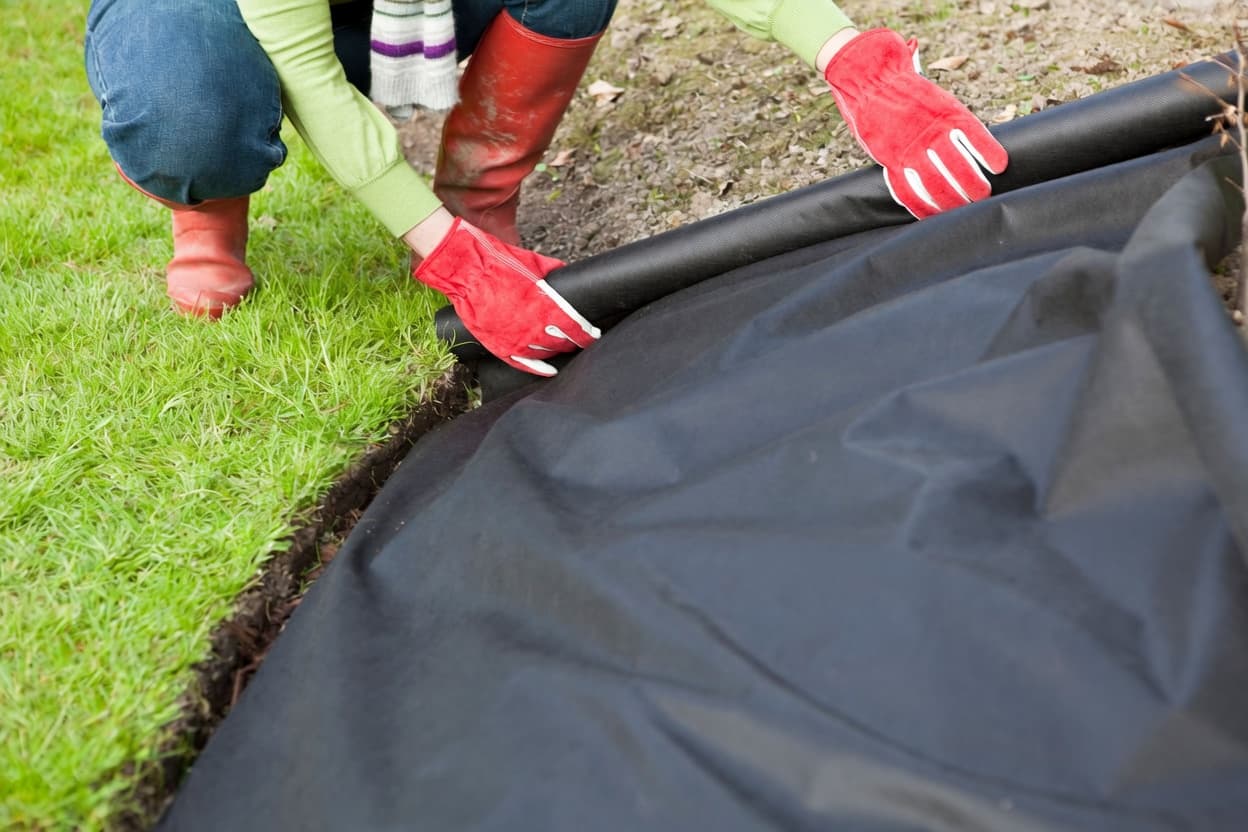 Weed barrier and seamed artificial turf panels during installation